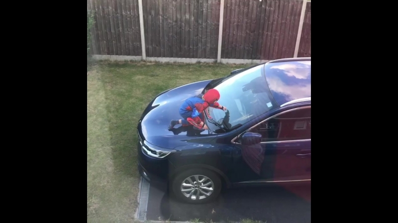 Little lad in a spider man costume climbs on his parents car and shoots