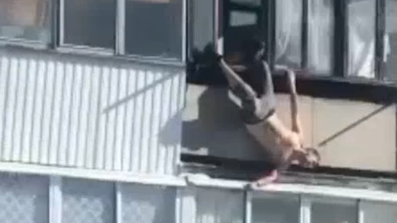 Полуголый спайдермен свисает с балкона вниз головой. Real